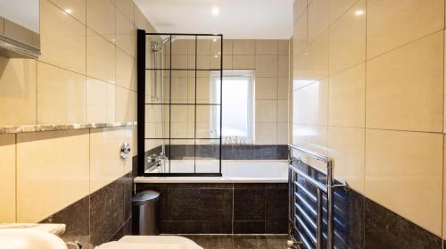 a bathroom with a tub and a toilet and a sink at Notting Hill Luxury Duplex in London