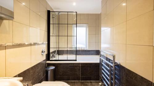 een badkamer met een bad, een toilet en een wastafel bij Notting Hill Luxury 3BR Duplex Modern Spacious Gem in Londen