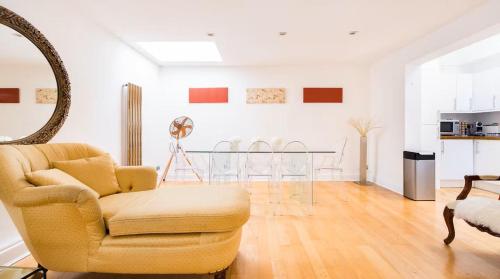 a living room with a chair and a table at Notting Hill Luxury 3BR Duplex Modern Spacious Gem in London