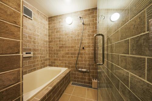 a bathroom with a bath tub and a shower at Mibu Hanabusa House in Kyoto