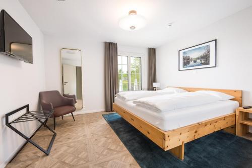een slaapkamer met een groot bed en een stoel bij Klein Rigi in Schönenberg