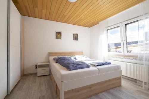 1 dormitorio con 1 cama con techo de madera en 65 qm Ferienwohnung im Sauerland, en Finnentrop