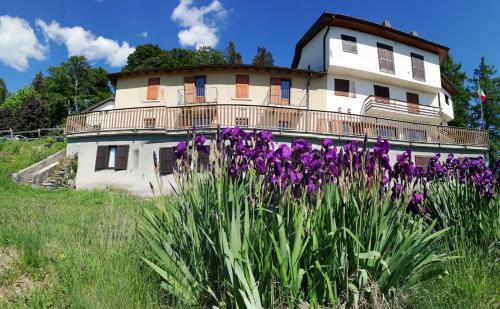 ein altes Haus mit lila Blumen davor in der Unterkunft Rifugio Campiglio in Dumenza