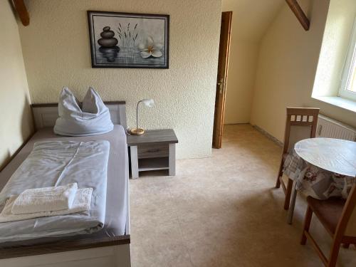 a bedroom with a bed and a table with a lamp at Zimmervermietung Graupner in Rossau