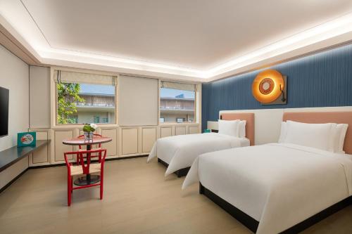 a hotel room with two beds and a table at Hotel Indigo Guangzhou Haixinsha by IHG - Free Shuttle Bus to Canton Fair Complex during Canton Fair period in Guangzhou