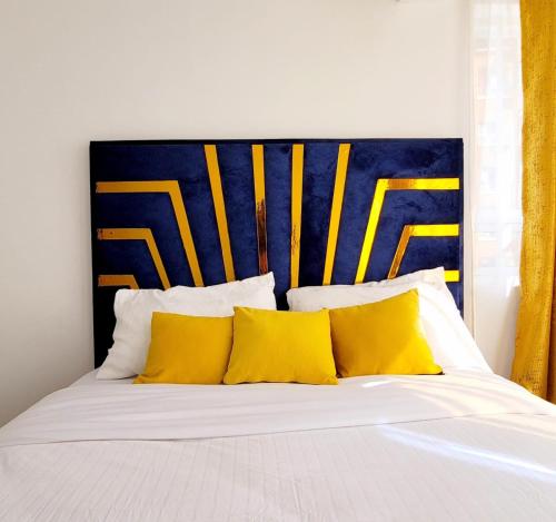 a bed with yellow pillows and a blue and yellow headboard at Newly Furnished 1-bedroom in Nairobi