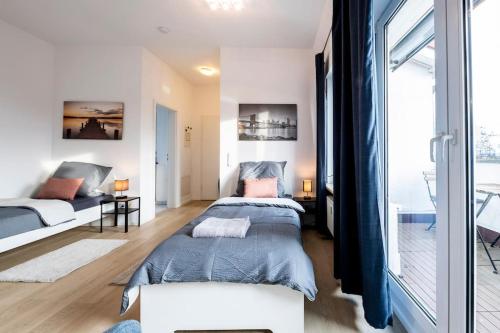 een slaapkamer met 2 bedden en een groot raam bij SU02 Work & Stay in Groß-Gerau! in Groß-Gerau