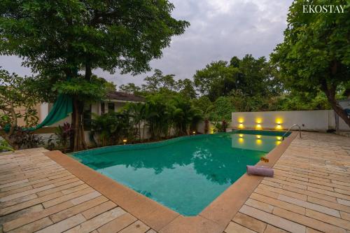 a swimming pool in front of a house at EKO STAY - Solace Villa I Charming Villa close to Candolim Beach in Candolim