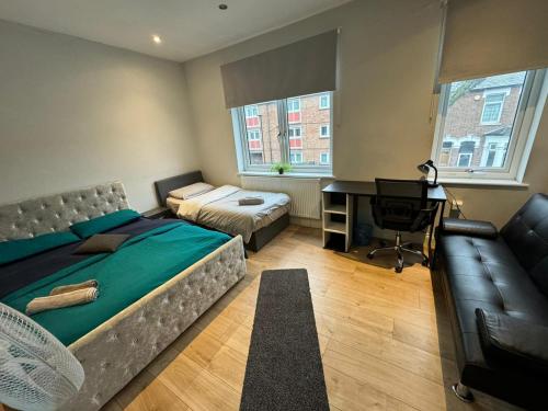 a bedroom with a bed and a desk and a couch at Fenia stay in London