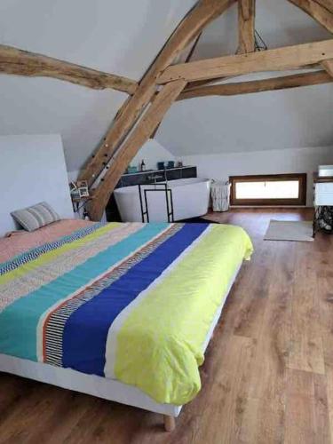 une chambre avec un lit et un parquet dans l'établissement L'Echo de la Nature, à Sasseville