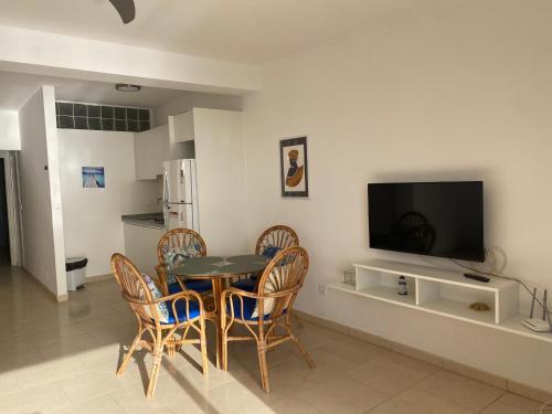 een keuken en eetkamer met een tafel en stoelen bij Aparthotel Praia Baixo in São Tiago