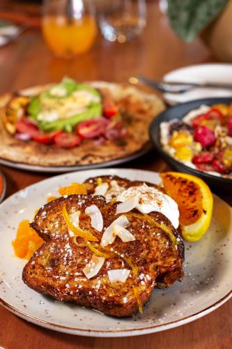 a plate of food on a table with plates of food at The Tokyo Aparthotel by Totalstay in Cape Town