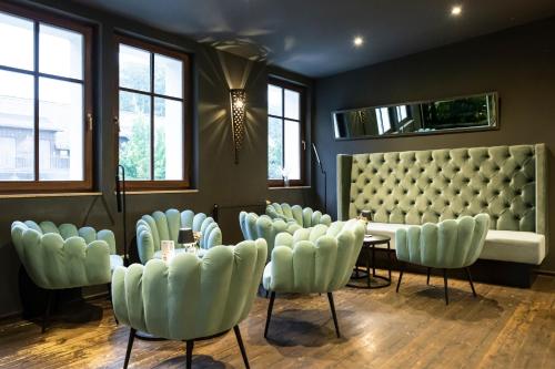 a room with a table and chairs and windows at Landhotel Burg im Spreewald - Resort & Spa in Burg