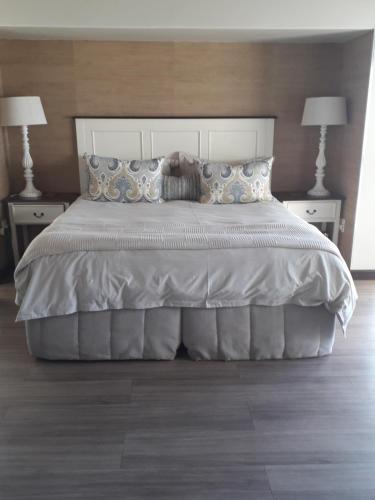 a bedroom with a bed with two nightstands and two lamps at Little Rock Guesthouse in Jongensfontein