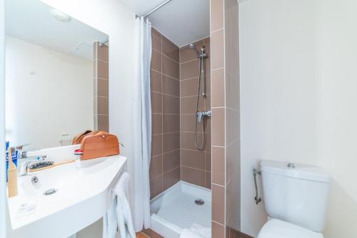 a bathroom with a shower and a sink and a toilet at Montempô Apparthôtel Paris-Vélizy in Vélizy-Villacoublay