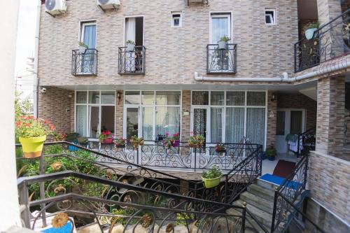 a house with a balcony with potted plants on it at GUEST HOUSE OCEAN FORCE in Batumi