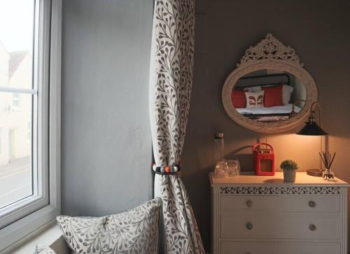 Luxurious Town House for 4 in Desirable Ludlow - pet friendly في لودلو: غرفة نوم مع خزانة ومرآة بجوار النافذة
