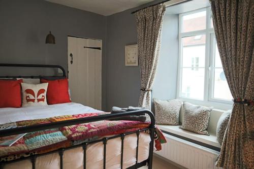 a bedroom with a bed sitting next to a window at Aragon Cottage in Ludlow