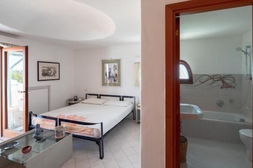 - une chambre avec un lit, une baignoire et un lavabo dans l'établissement Villa Felice - Circeo, à SantʼAlfonso