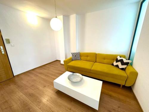 a living room with a yellow couch and a coffee table at Carolina Residence in Alba Iulia