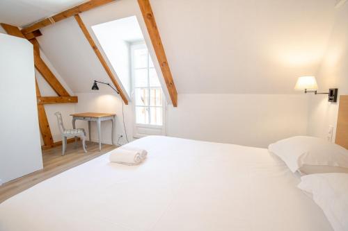 a white bed in a room with a window at Le cosy pad in Amboise