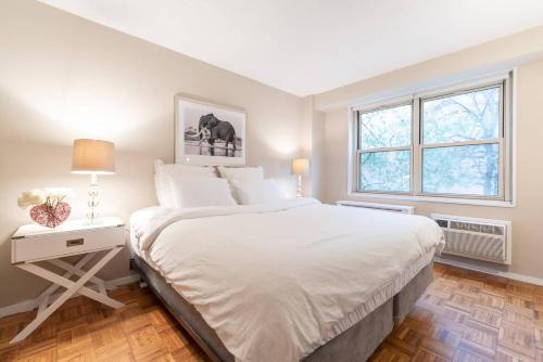 biała sypialnia z dużym łóżkiem i oknem w obiekcie 1600ft TriBeCa Townhouse - Luxury & Spacious w Nowym Jorku