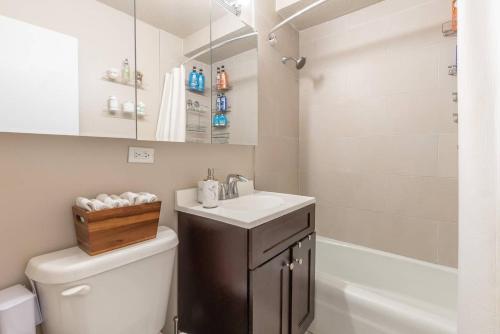 La salle de bains est pourvue d'un lavabo, de toilettes et d'une baignoire. dans l'établissement 1600ft TriBeCa Townhouse - Luxury & Spacious, à New York