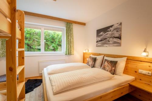 1 dormitorio con cama y ventana en Haus Floria Top 2, en Neukirchen am Großvenediger