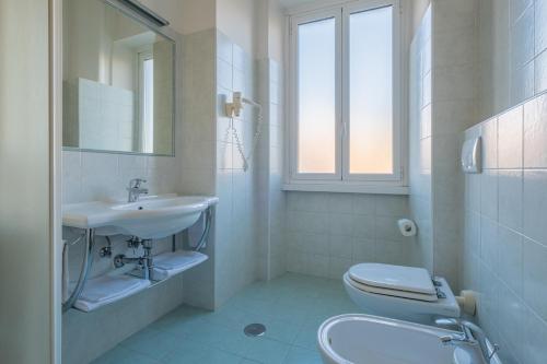 bagno bianco con lavandino e servizi igienici di Hotel Monte Verde a Roma