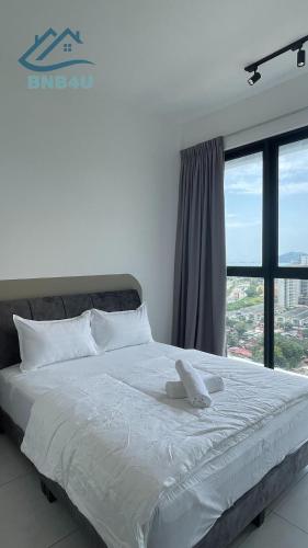 a white bed in a room with a large window at Urban Suites Georgetown by BNB4U in Jelutong