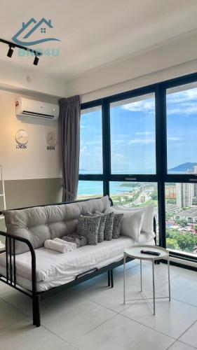 a white couch in a room with large windows at Urban Suites Georgetown by BNB4U in Jelutong
