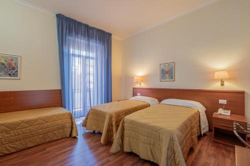 ローマにあるHotel Monte Verdeのベッド2台と窓が備わるホテルルームです。