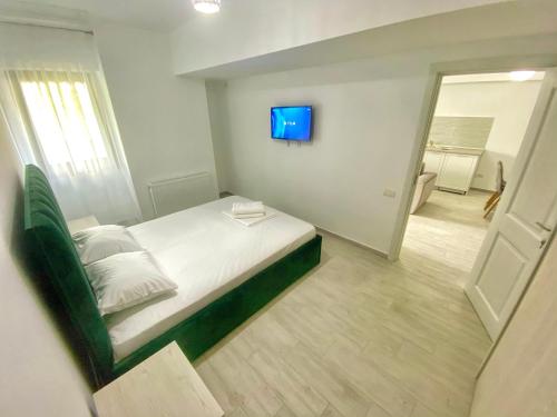 um quarto com uma cama e uma televisão na parede em Aqua Apartament Mamaia em Mamaia