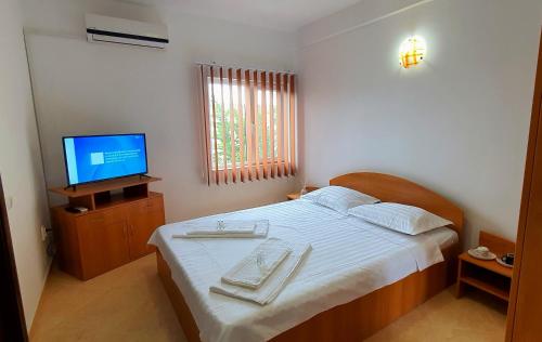 a bedroom with a bed with a television and towels on it at Casa Ruby in Mangalia