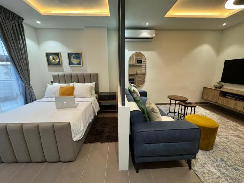 een slaapkamer met een bed, een bank en een stoel bij Studio Apartment in Accra