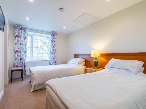 een slaapkamer met 2 bedden en een raam bij 4 Bed in Langtoft 81235 in Weaverthorpe