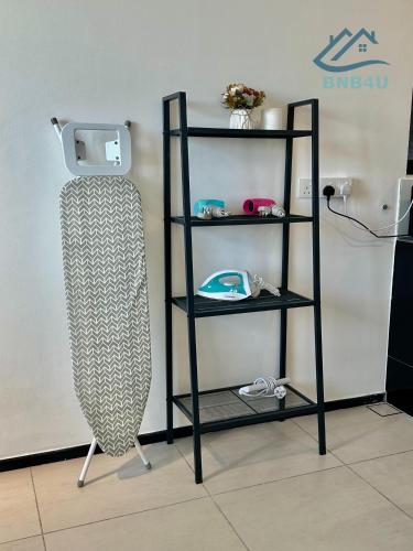 a black book shelf with two shelves next to a wall at Urban Suites Georgetown by BNB4U in Jelutong