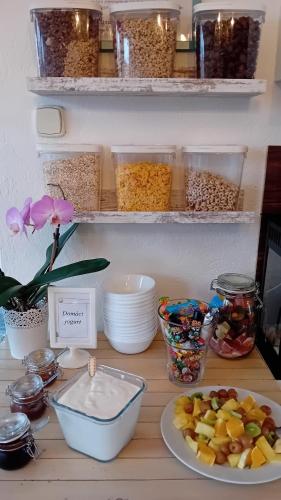 a counter with bowls of food and a plate of fruit at Penzión Vilka Podhájčanka in Podhájska