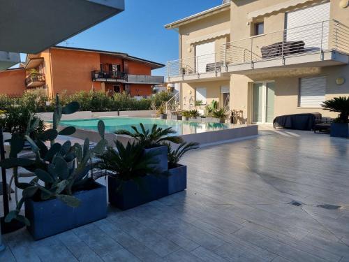 a courtyard with plants and a swimming pool at Aura Mura in Peschiera del Garda