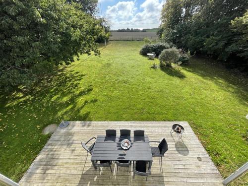 an overhead view of a picnic table and chairs on a deck at Havlykkegaard - en unik gammel dame ved Østersøen in Idestrup