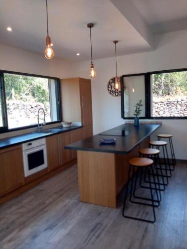 une cuisine avec un grand îlot et des tabourets de bar dans l'établissement VILLA I BAGHI - sans vis-à-vis au calme, à Sainte-Lucie de Porto-Vecchio