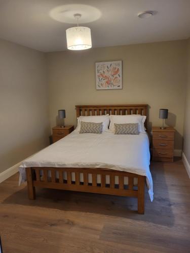 a bedroom with a large bed and two night stands at Blackriver House in Shruthair