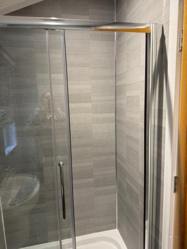 um homem tirando uma foto de um chuveiro em uma casa de banho em V+B Hygge em Windermere