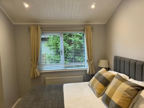 a bedroom with a bed and a window at V+B Hygge in Windermere