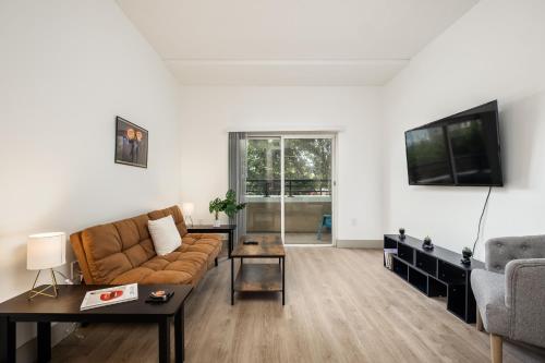 een woonkamer met een bank en een tv bij CityScape Flat- 3BR Luxury APT in Uptown in Charlotte