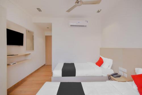 Habitación blanca con cama y TV de pantalla plana. en THE PARADISE INTERNATIONAL en Coimbatore