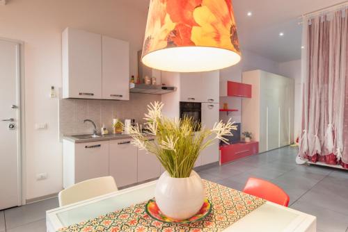 eine Küche und ein Esszimmer mit einer Vase auf dem Tisch in der Unterkunft Casa Cellini - Piombino Apartments in Piombino