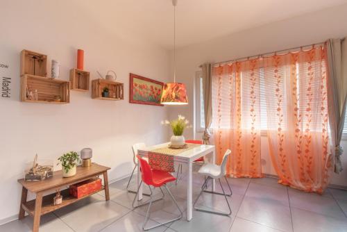 ein Esszimmer mit einem Tisch, Stühlen und einem Fenster in der Unterkunft Casa Cellini - Piombino Apartments in Piombino