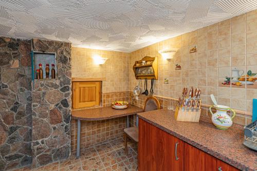 a kitchen with a counter and a stone wall at Spacious Studio apartment by Polo apartments in Kaunas