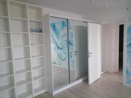 a glass shower in a room with white shelves at Luxury 4-rooms, 2-bathrooms, Obor area in Bucharest